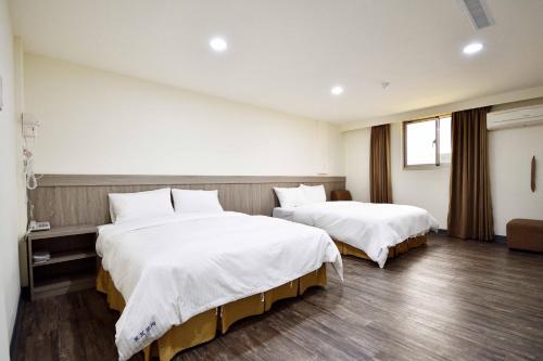 Łóżko lub łóżka w pokoju w obiekcie 新灣商旅