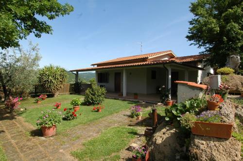 ein Haus mit einem Hof mit Blumen und Pflanzen in der Unterkunft Agriturismo San Vincenzo in Sovana