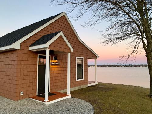a small shed with a lake in the background at Harbor View Landing in Mystic