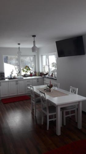 a white kitchen with a white table and chairs at Pension Casa Contelui in Râşnov