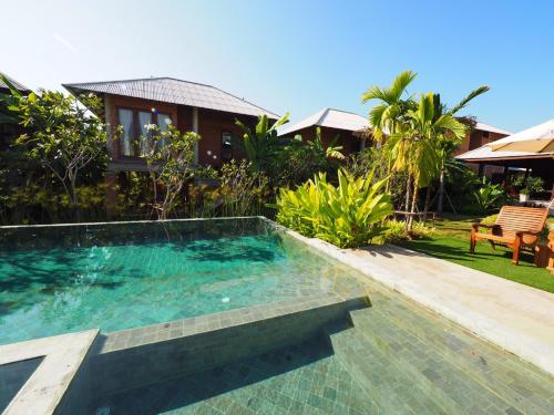 a swimming pool in front of a house at BaanSuk Sukhothai Resort in Sukhothai