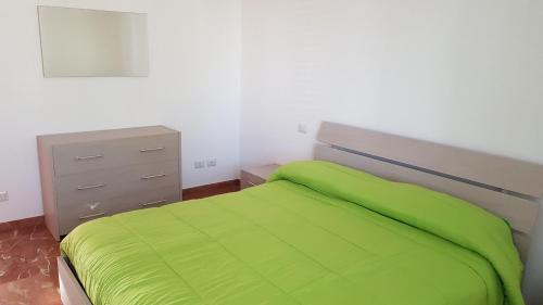 a bedroom with a green bed and a dresser at Da Pietro in Pietra in La Martella