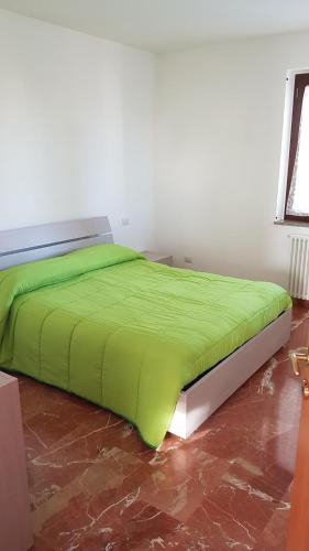a bed with a green comforter in a room at Da Pietro in Pietra in La Martella