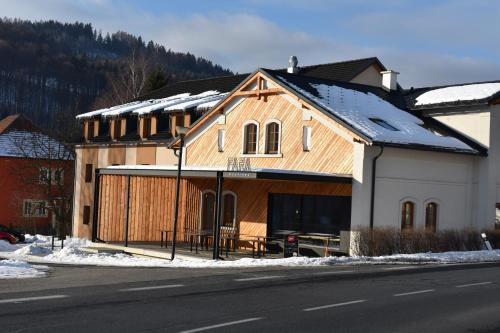a large wooden building on the side of the street at Apartma FARA in Loučná nad Desnou