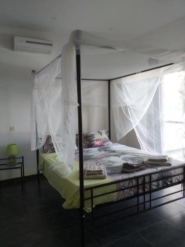 a bedroom with a bed with a canopy at Villa contemporaine au calme sans vis à vis piscine privée in Somone