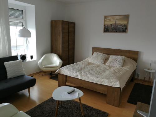 1 dormitorio con 1 cama, 1 sofá y 1 silla en Ida Apartman, en Miskolc