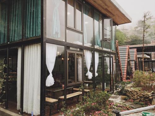 a house with glass doors and windows on it at Bách Xanh House. Nhà Gác Lửng in Vĩnh Phúc