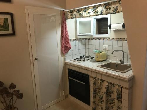 a small kitchen with a sink and a stove at casa nonna Fiora in Fasano