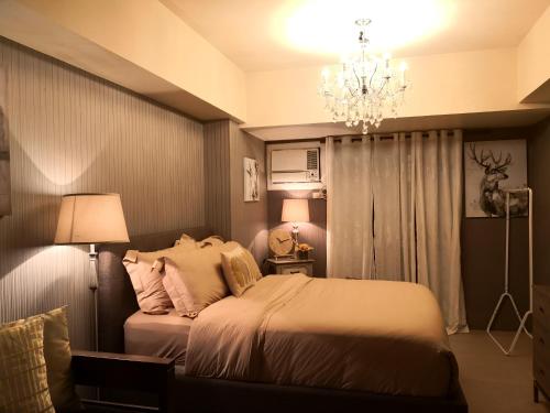 una camera con letto e lampadario a braccio di Centrio Tower Beside Ayala Studio Unit with Balcony 23 a Cagayan de Oro