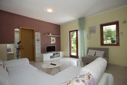 a living room with a white couch and a tv at Apartment Lucy in Split