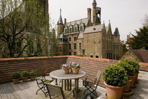 un patio con mesa y sillas y un edificio en B&B Exclusive Guesthouse Bonifacius, en Brujas