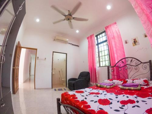 a bedroom with a red and white bed and a ceiling at Desa Tunjung Homestay in Kangar