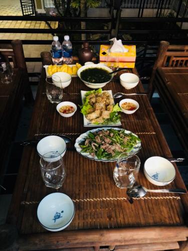 a wooden table with plates of food on it at Ninh Binh Brother's Homestay in Ninh Binh