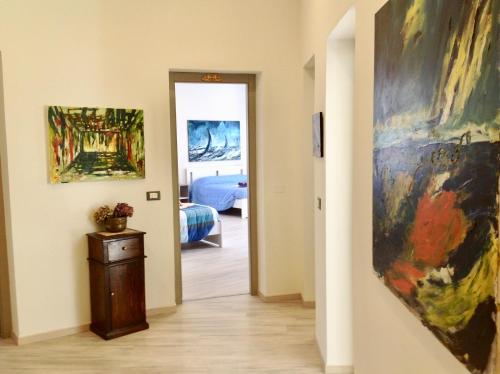 a hallway with a painting on the wall and a bedroom at Sicania in Patti