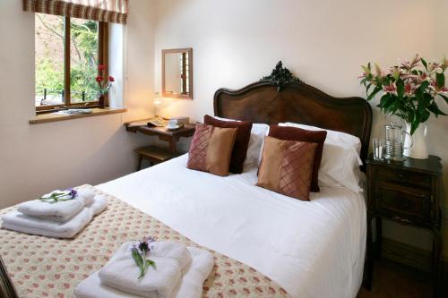 a bedroom with a bed with towels on it at Arbor Holiday Cottages in Southam