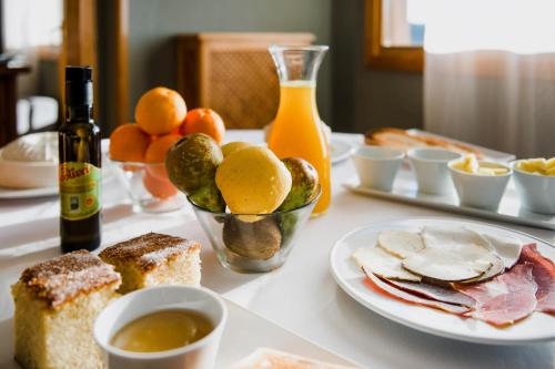 a table with a plate of bread and fruit and a bottle of wine at Hotel El Cid in Morella