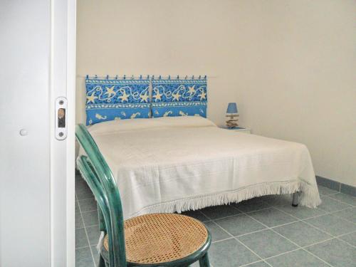 sypialnia z łóżkiem z niebieskim zagłówkiem i krzesłem w obiekcie Casa vacanze Dune sul mare w mieście San Pietro in Bevagna