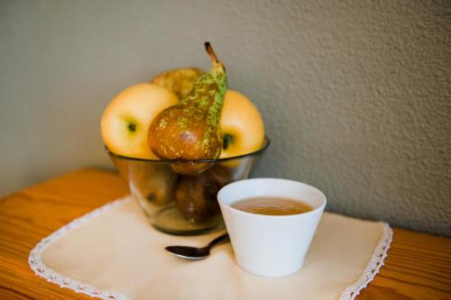 a bowl of apples and a cup of coffee on a table at Hotel El Cid in Morella
