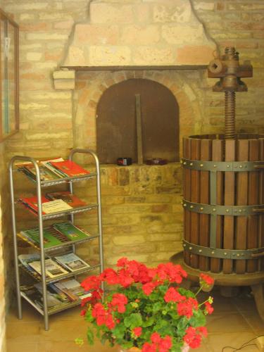 a room with a fireplace and a barrel and flowers at Il Giardino Degli Ulivi in Appignano