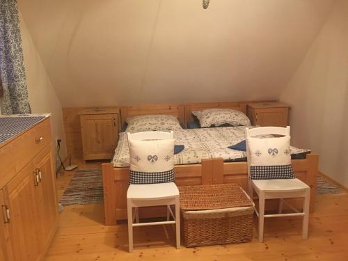 1 Schlafzimmer mit einem Bett und 2 Stühlen in der Unterkunft Chata ObšÍvanka in Terchová