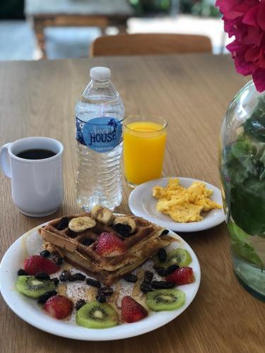 a table with two plates of breakfast food and a bottle of water at Summer House Inn San Andres in San Andrés