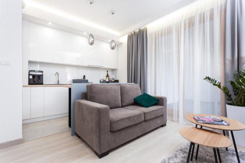 a living room with a couch and a kitchen at City of the Kings - Inca Apartment in Krakow