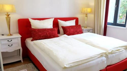 a bedroom with a red and white bed with red pillows at "Bellevue" Villa Andrea in Baabe