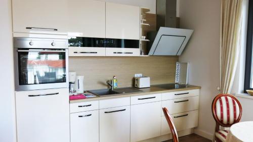 a kitchen with white cabinets and a white refrigerator at "Bellevue" Villa Andrea in Baabe