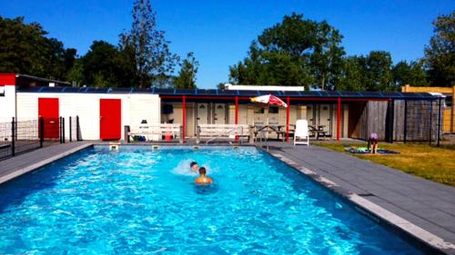 a person in the water in a swimming pool at Vacation Home 72 in Tzummarum