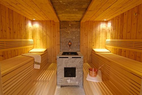a sauna with a fireplace in the middle of it at Hotel Talblick in Ortisei