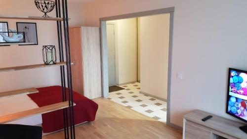 a living room with a room with a door and a television at Girelės apartamentai in Kaišiadorys