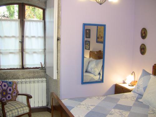 a bedroom with a bed and a mirror and a chair at Casa Xan da Pena in Villarmayor