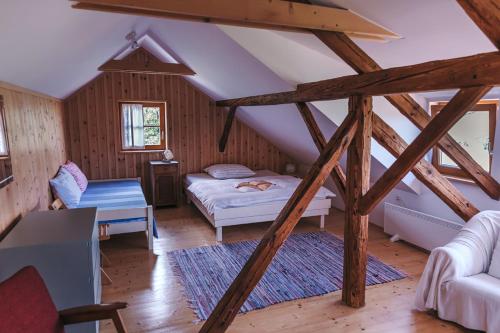 Slovenske KonjiceにあるMala Kmetijaのベッドルーム1室(ベッド1台、屋根裏部屋のソファ付)