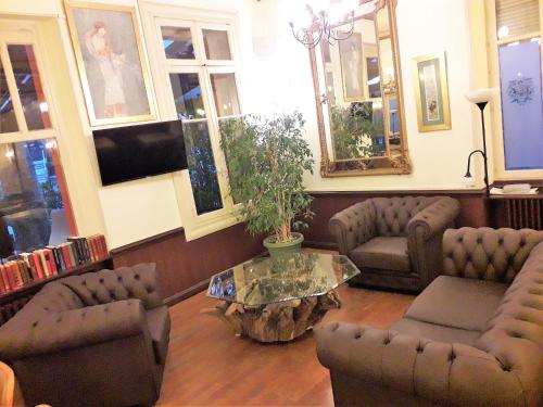 salon z kanapami i stolikiem kawowym w obiekcie Hôtel Belleville w mieście Lamalou-les-Bains