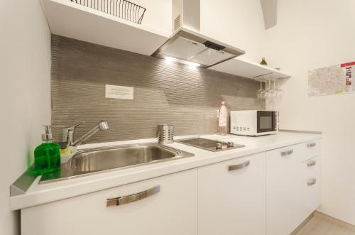 uma cozinha com um lavatório e um micro-ondas em Le Torri Suite, Davanzale vista Due Torri em Bolonha