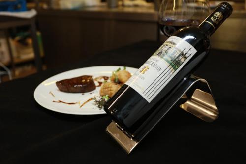 a bottle of wine sitting on a table with a plate of food at Vaughan Lodge Hotel in Lahinch