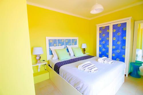 a bedroom with two beds with yellow and blue walls at RiaMar - Praia da Vagueira in Gafanha da Vagueira