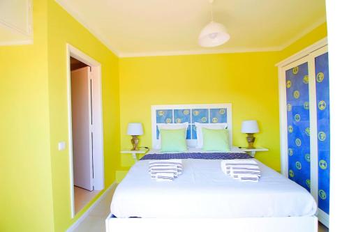 a bedroom with a large bed with yellow walls at RiaMar - Praia da Vagueira in Gafanha da Vagueira