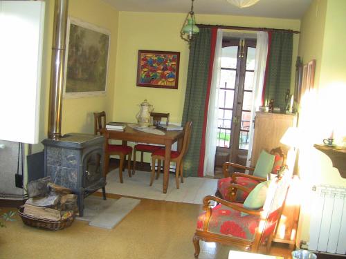 a living room with a stove and a table with chairs at Casa Xan da Pena in Villarmayor