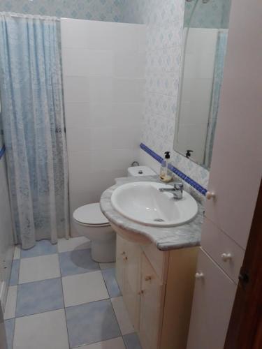 a bathroom with a sink and a toilet and a mirror at Casa amaro in Vejer de la Frontera