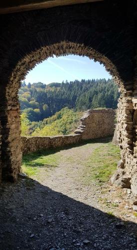 an archway in a stone wall with a view at Gast und Weinhof Beim Schneemann in Valwig