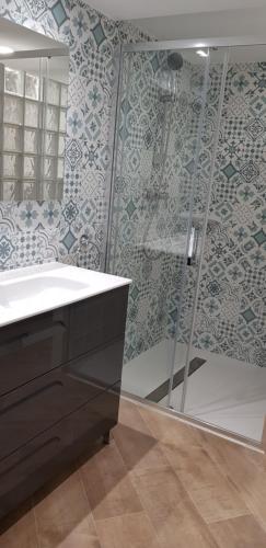 a bathroom with a shower and a sink and a mirror at Apartamentos Montgò in Denia