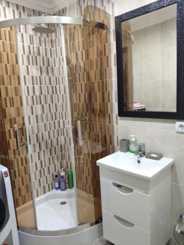 ein Bad mit einer Dusche und einem Waschbecken in der Unterkunft Квартира in Tiraspol