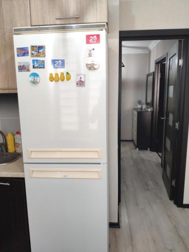 a white refrigerator freezer sitting in a kitchen at Квартира in Tiraspol