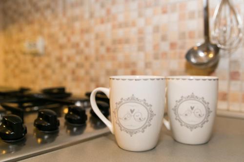 two coffee cups sitting on top of a stove at Apartmani Strsoglavec in Krapinske Toplice