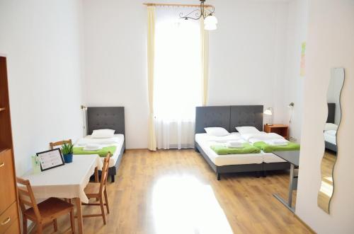 a room with two beds and a table and chairs at WenderEDU Business Center in Wrocław