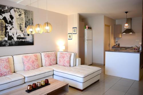 a living room with a white couch and a table at Hanalei duplex - downtown Papeete - 1 bedroom - AC - WiFi - 2 persons in Papeete