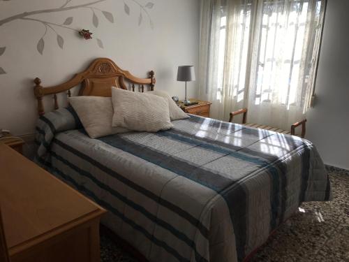 a bedroom with a bed with a blue and gray blanket at "La Chacra" Casa Típica Valenciana in Godella