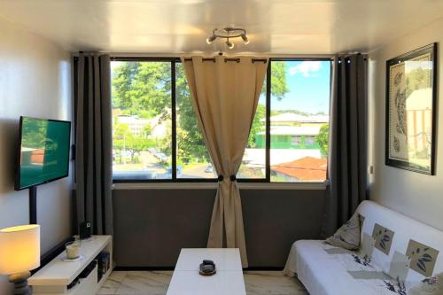 uma sala de estar com uma grande janela e um sofá em Ery apartment - Papeete downtown - 2 bedrooms - AC - WiFi - 6 pers em Papeete