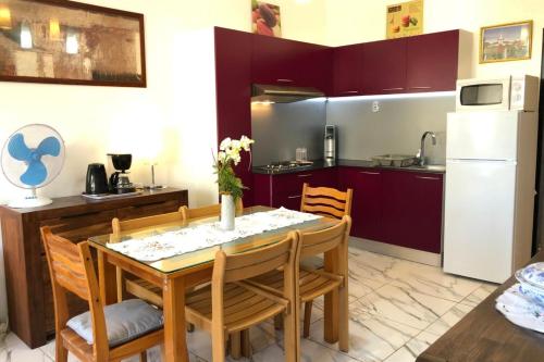 パペーテにあるEry apartment - Papeete downtown - 2 bedrooms - AC - WiFi - 6 persのテーブルと椅子のあるキッチンとダイニングルーム